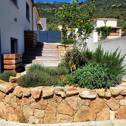 Escalier en bois et massif paysager sur terrain en pente